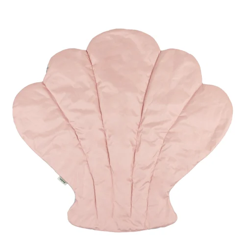 Shell-shaped quilted floor mat laid out in a nursery reading corner
